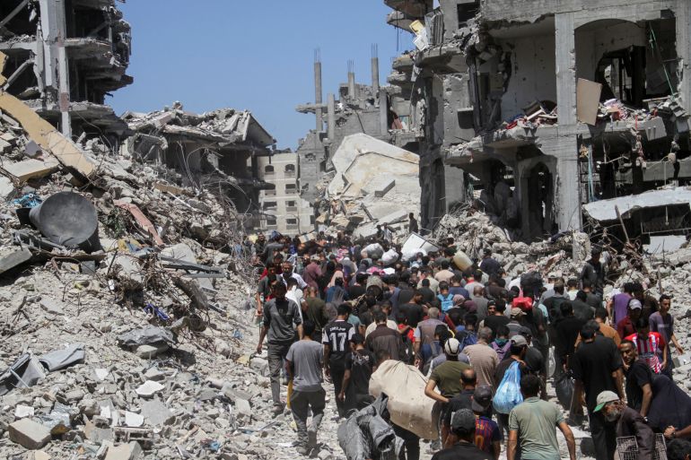 Palestinians make their way as they inspect the damages after Israeli forces withdrew from a part of Jabalia refugee camp, following a raid, in the northern Gaza Strip, May 30, 2024. REUTERS/Mahmoud Issa